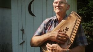 A Man Holding An Autoharp Showing Autoharp Performance Tips for Live Shows